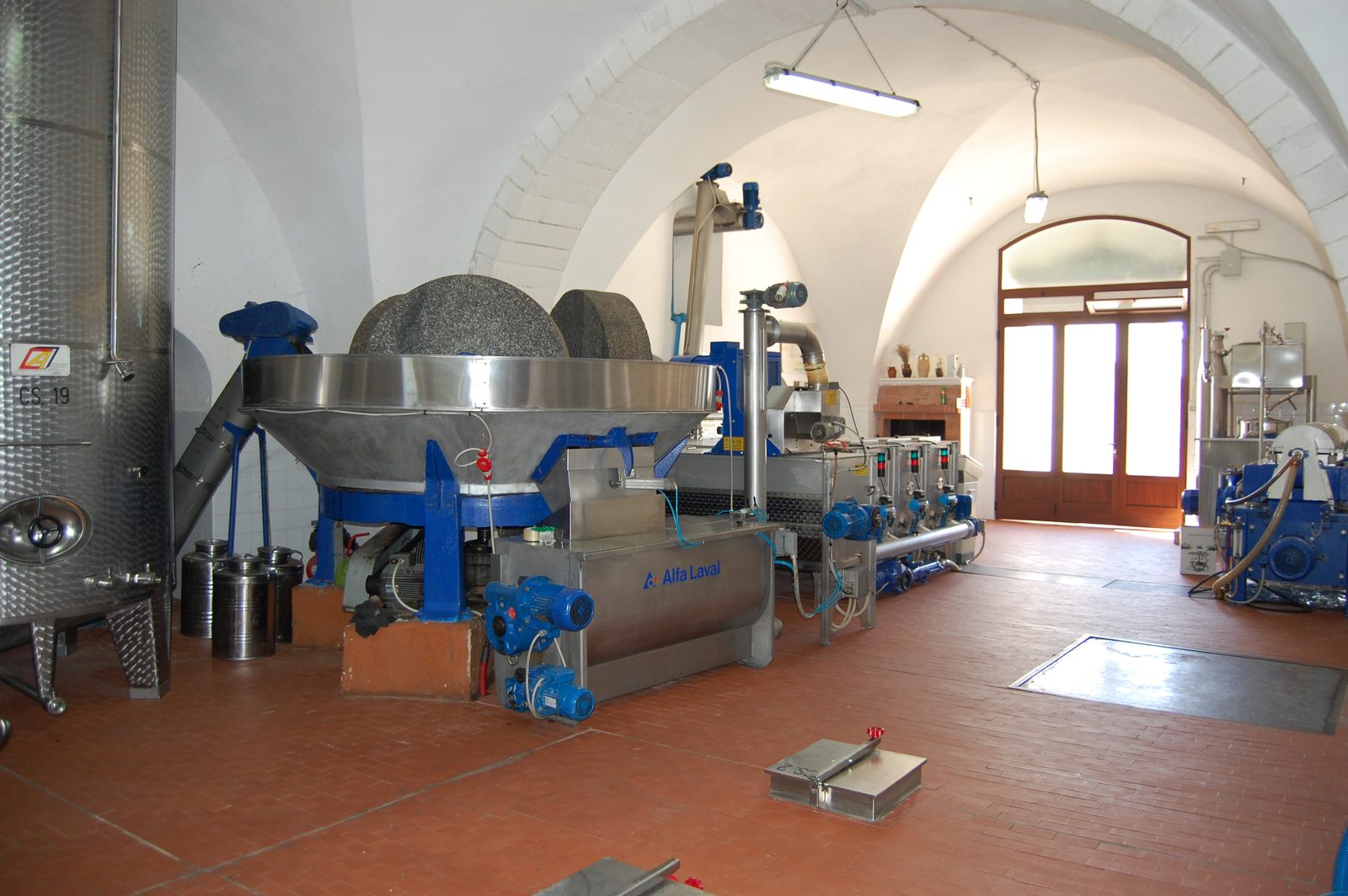 Pressanlage mit Edelstahlbehältern im Gewölbe der Mühle